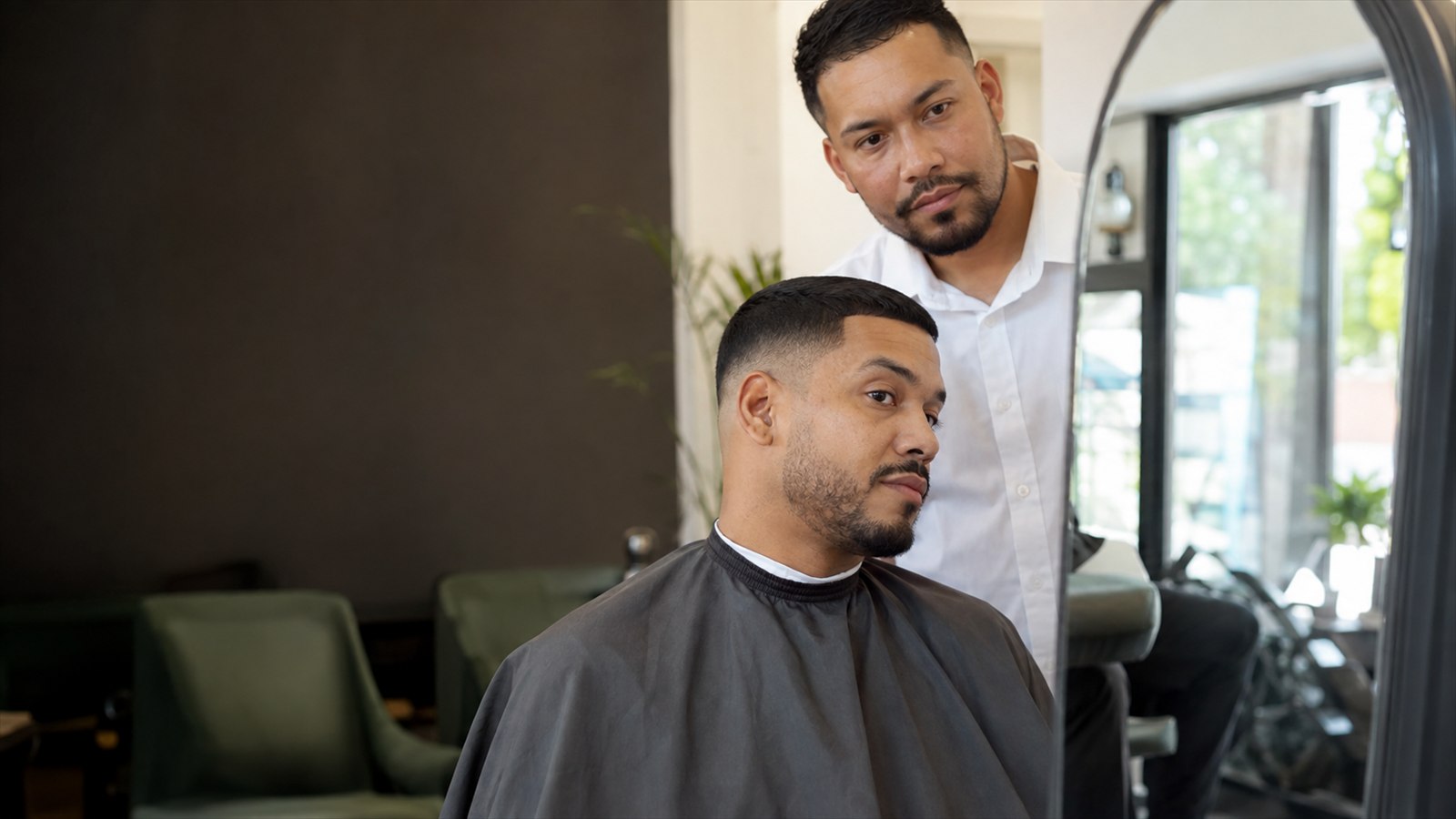 Barber and adult client checking a freshly finished fade in the mirror