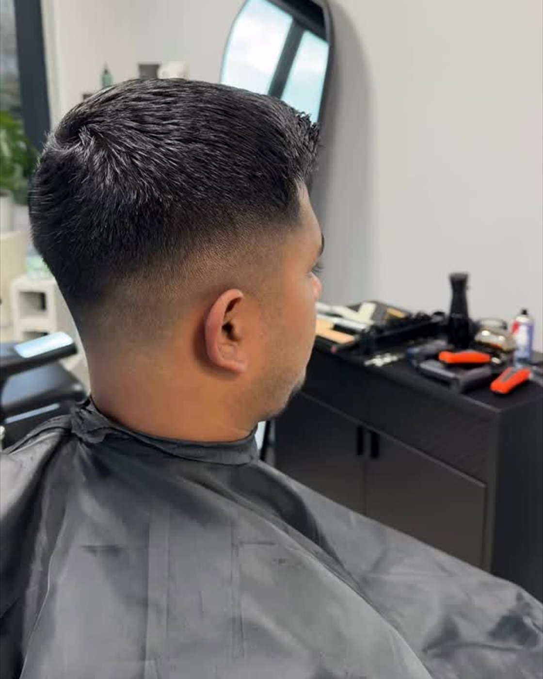 Rear view of a blended fade on an adult client inside a barbershop